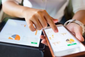Women looking at financial data on two different electronic devices